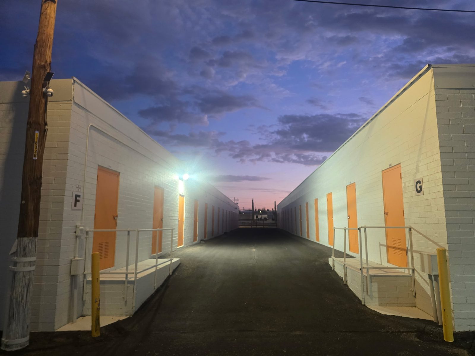 Lit drive aisle between buildings F and G at the Tucson facility at dusk